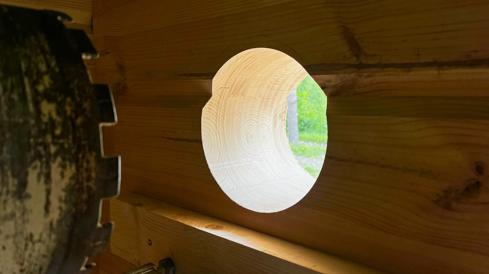 Tuvplāns precīzi izurbts apaļš caurums koka baļķu sienā ventilācijas sistēmai